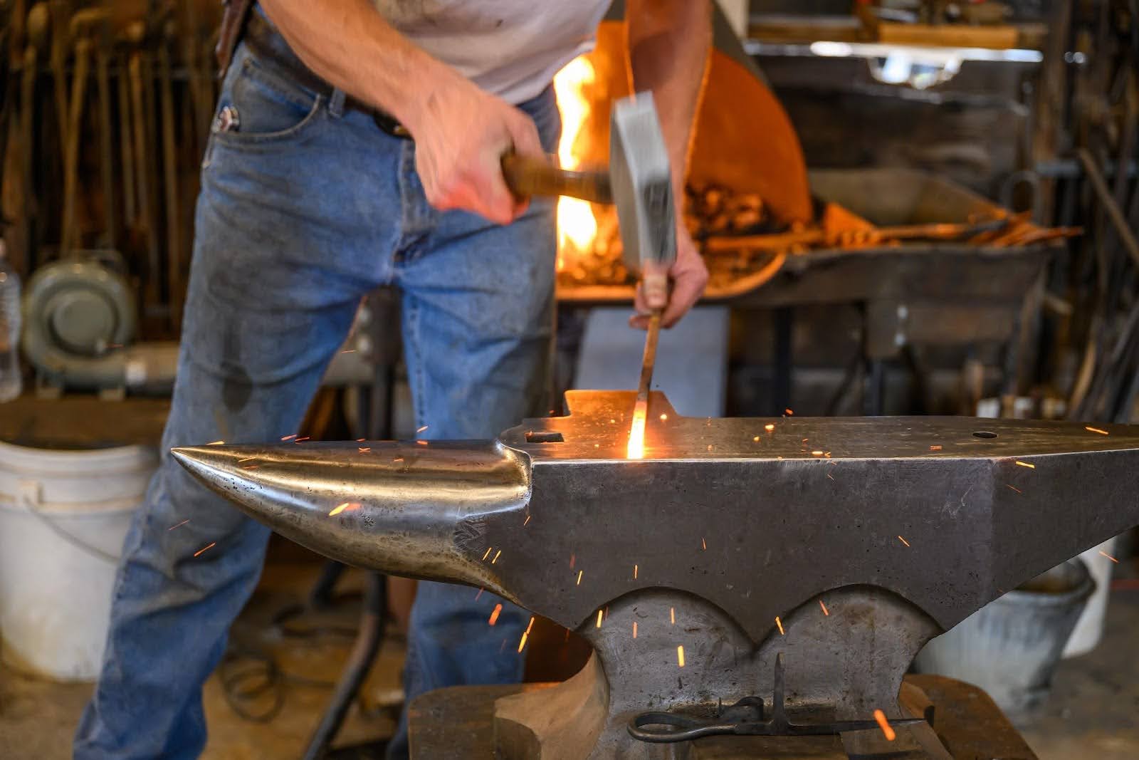 Blacksmith striking iron on an anvil