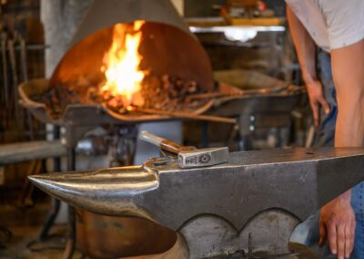 Blacksmith working at a live forge inside the Fort Hays Old West Town