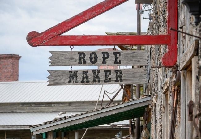Fort Hays boardwalk cabins with frontier tools displayed inside.